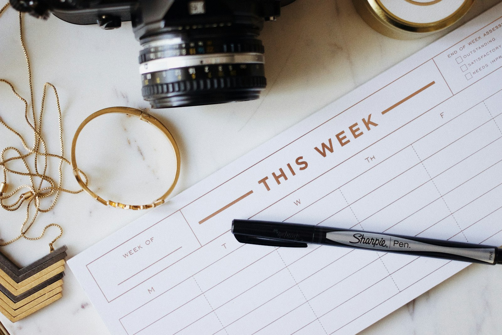 Een opengeslagen weekagenda met ingekleurde tijdblokken op een bureau