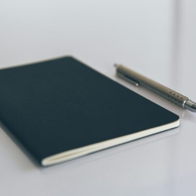 Opengeslagen notitieboek met een gewoontetracker en een pen