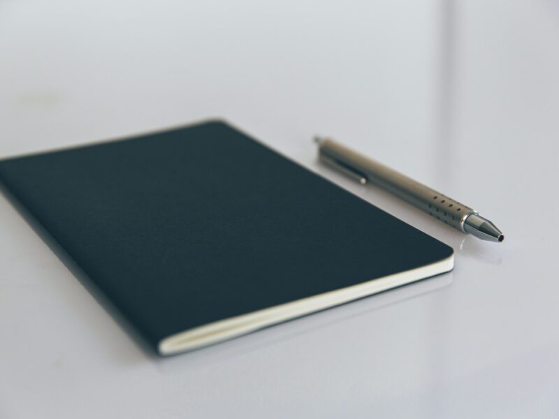 Opengeslagen notitieboek met een gewoontetracker en een pen