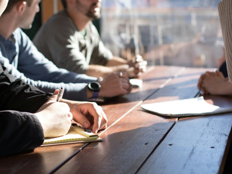 Werknemer in gesprek met een leidinggevende aan een tafel op kantoor