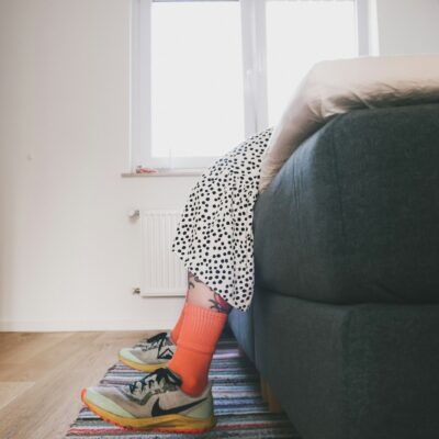 Hardloopschoenen en sportkleding klaargelegd naast een bed
