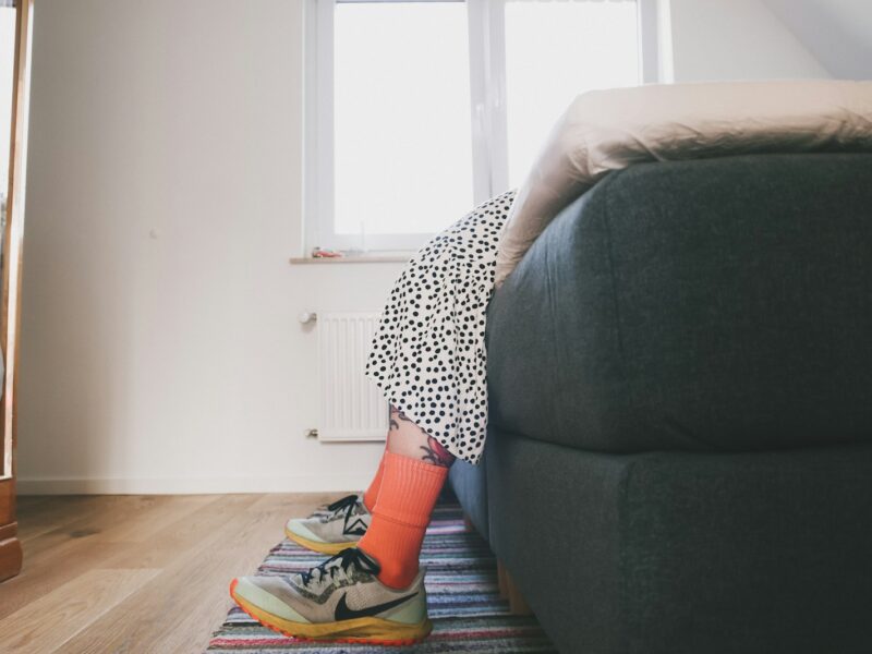 Hardloopschoenen en sportkleding klaargelegd naast een bed