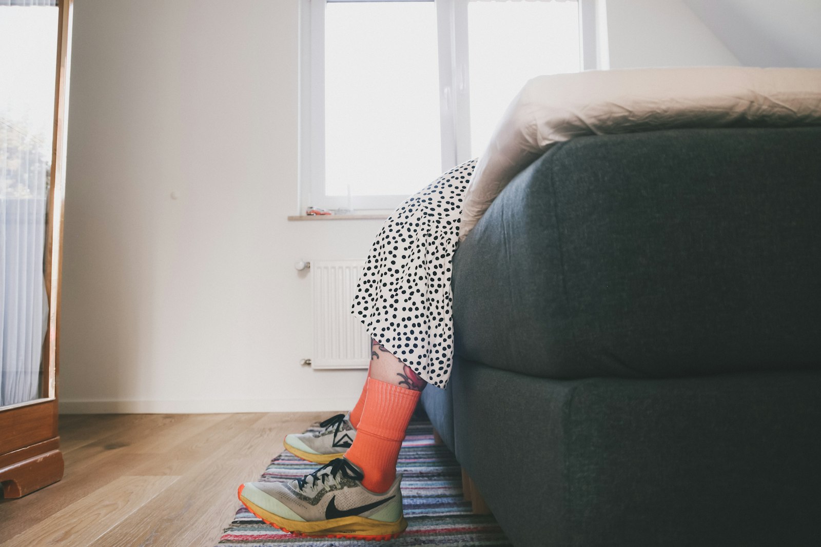 Hardloopschoenen en sportkleding klaargelegd naast een bed