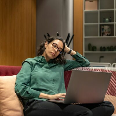 Vermoeide zelfstandige achter een laptop aan de keukentafel