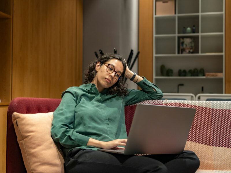 Vermoeide zelfstandige achter een laptop aan de keukentafel